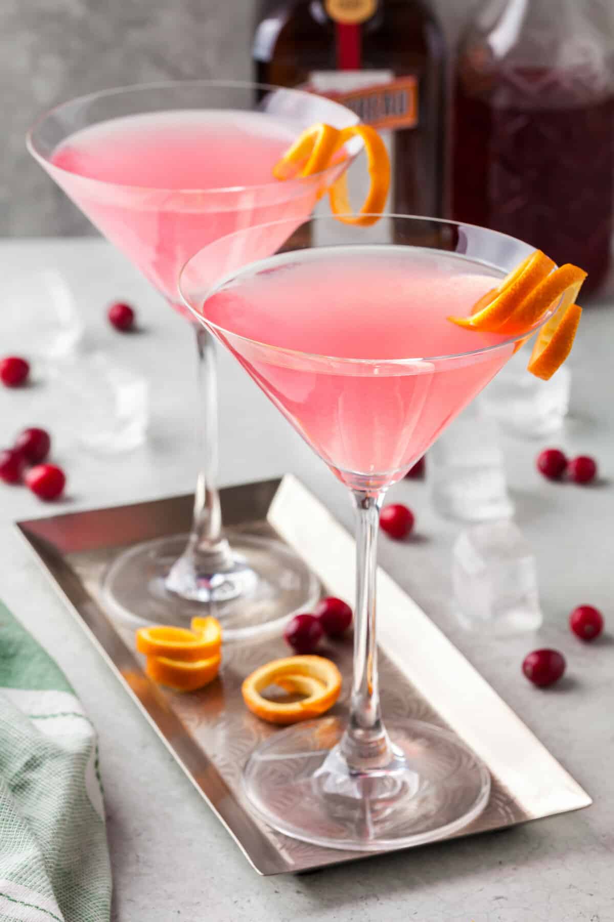 Two martini glasses are filled with pink cosmos. 