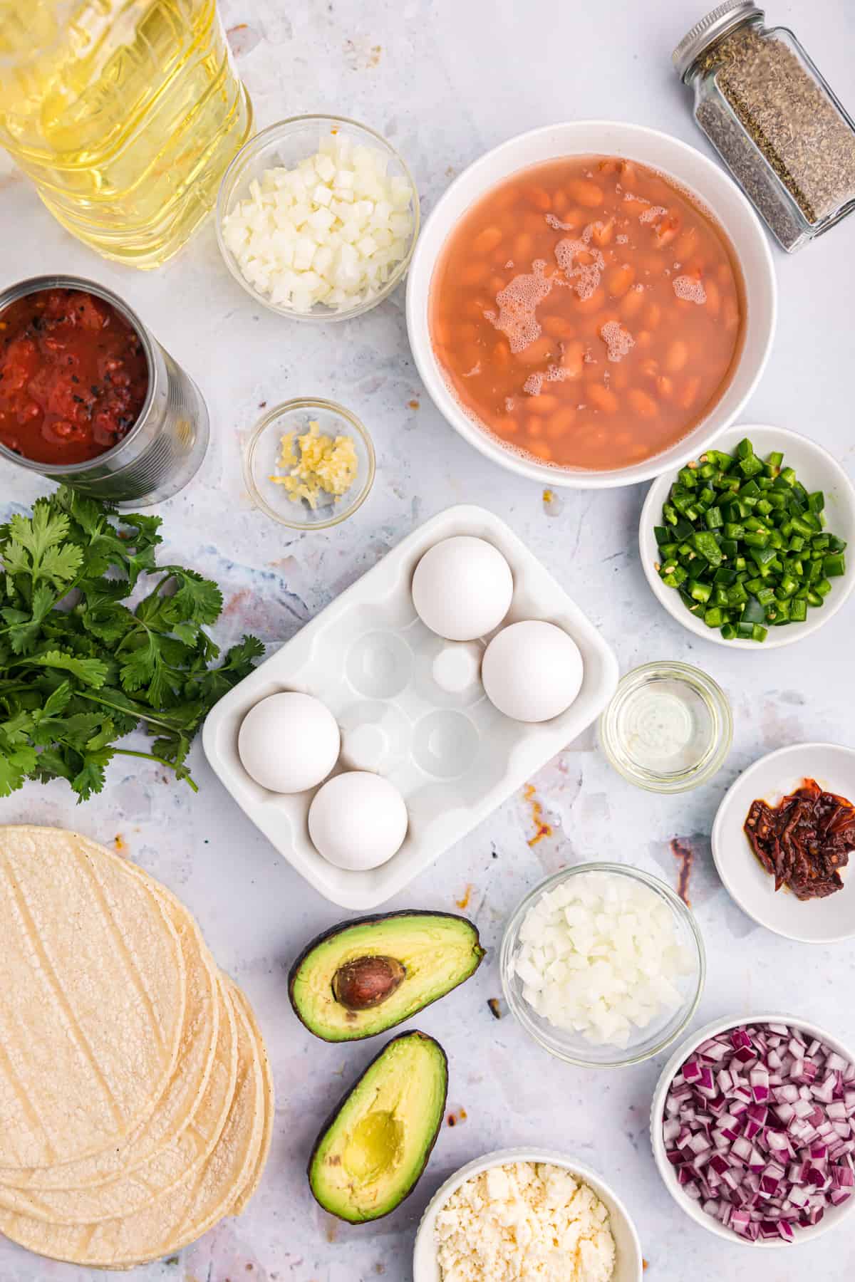 The ingredients for huevos rancheros are spread out across a countertop. 