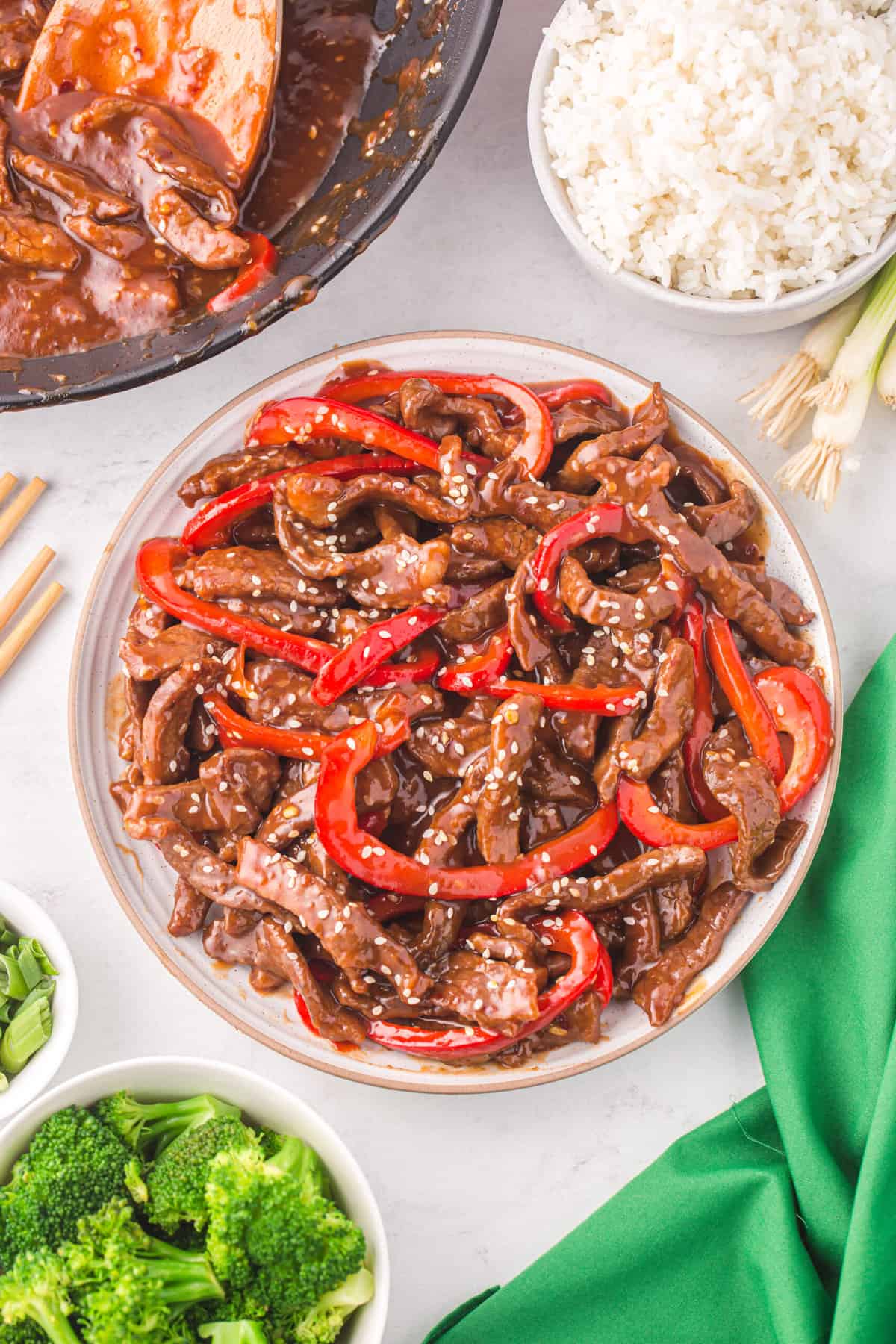 A white plate is topped with szechuan beef. 