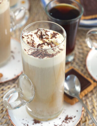 A garnished glass of affogato is placed on a small plate.