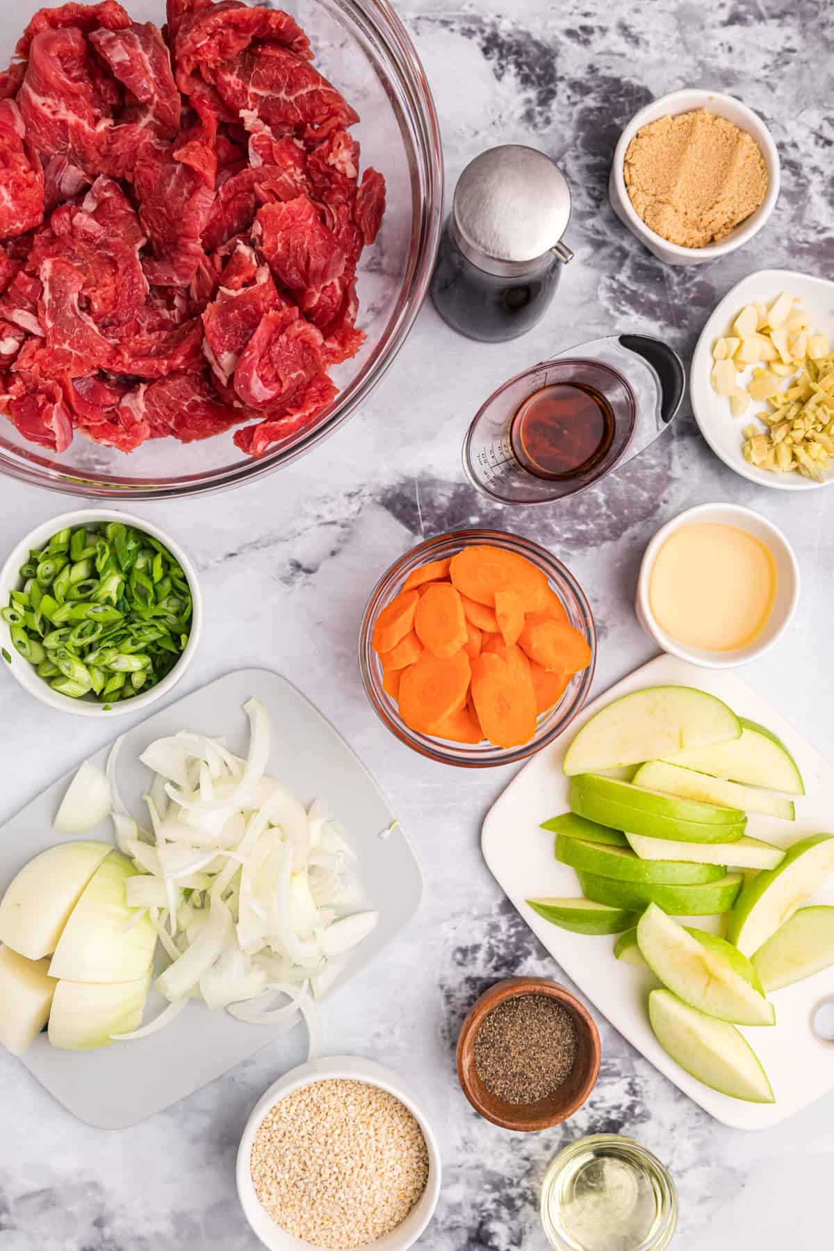 The ingredients for beef bulgogi are placed on a white surface. 