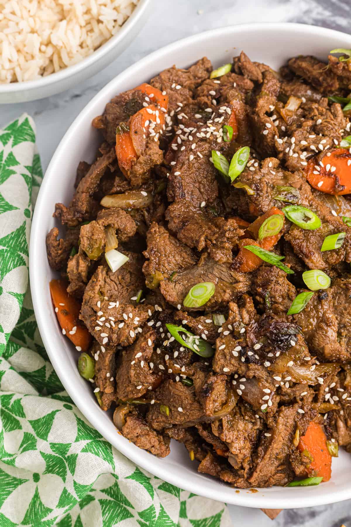 A serving of beef bulgogi is garnished with sesame seeds. 