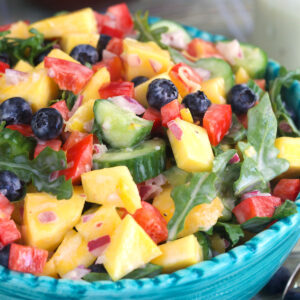 A large blue bowl is filled with mango salad.