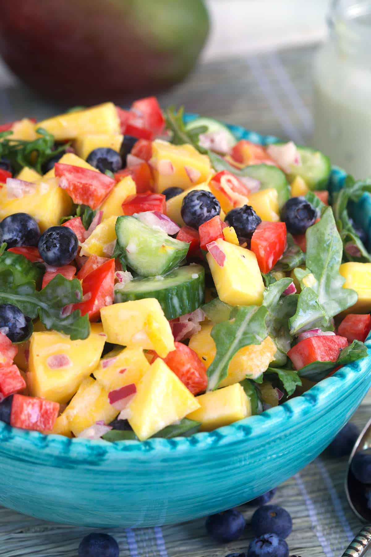 A large blue bowl is filled with mango salad. 