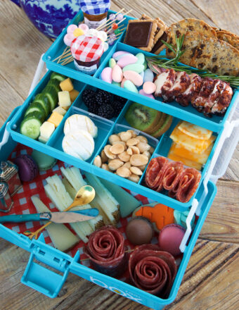 A tiered blue tackle box is filled with all different snacks.