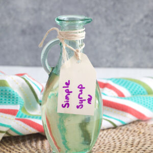 Glass bottle with a label marked Simple Syrup in purple marker.