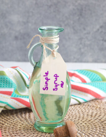 Glass bottle with a label marked Simple Syrup in purple marker.