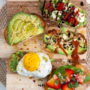 Several pieces of avocado toast are placed on a cutting board.