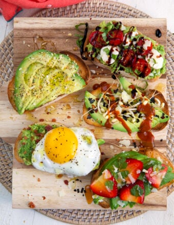 Several pieces of avocado toast are placed on a cutting board.