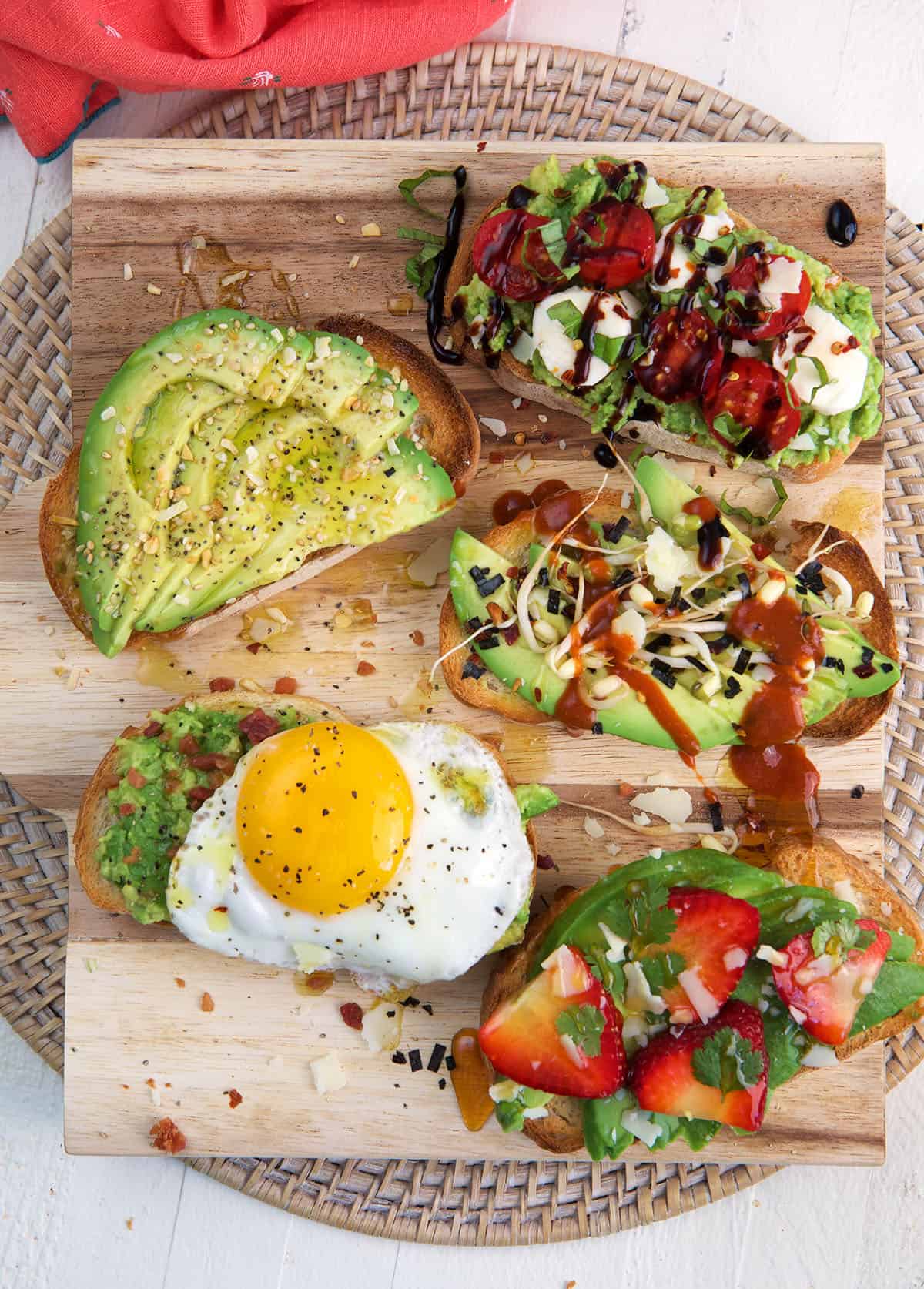 Several pieces of avocado toast are placed on a cutting board.