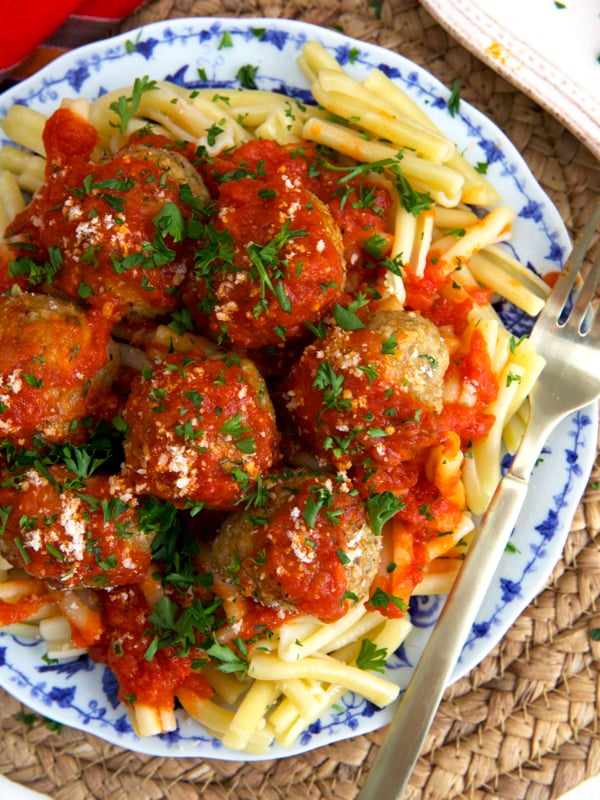 Pasta is served with red sauce and meatballs.