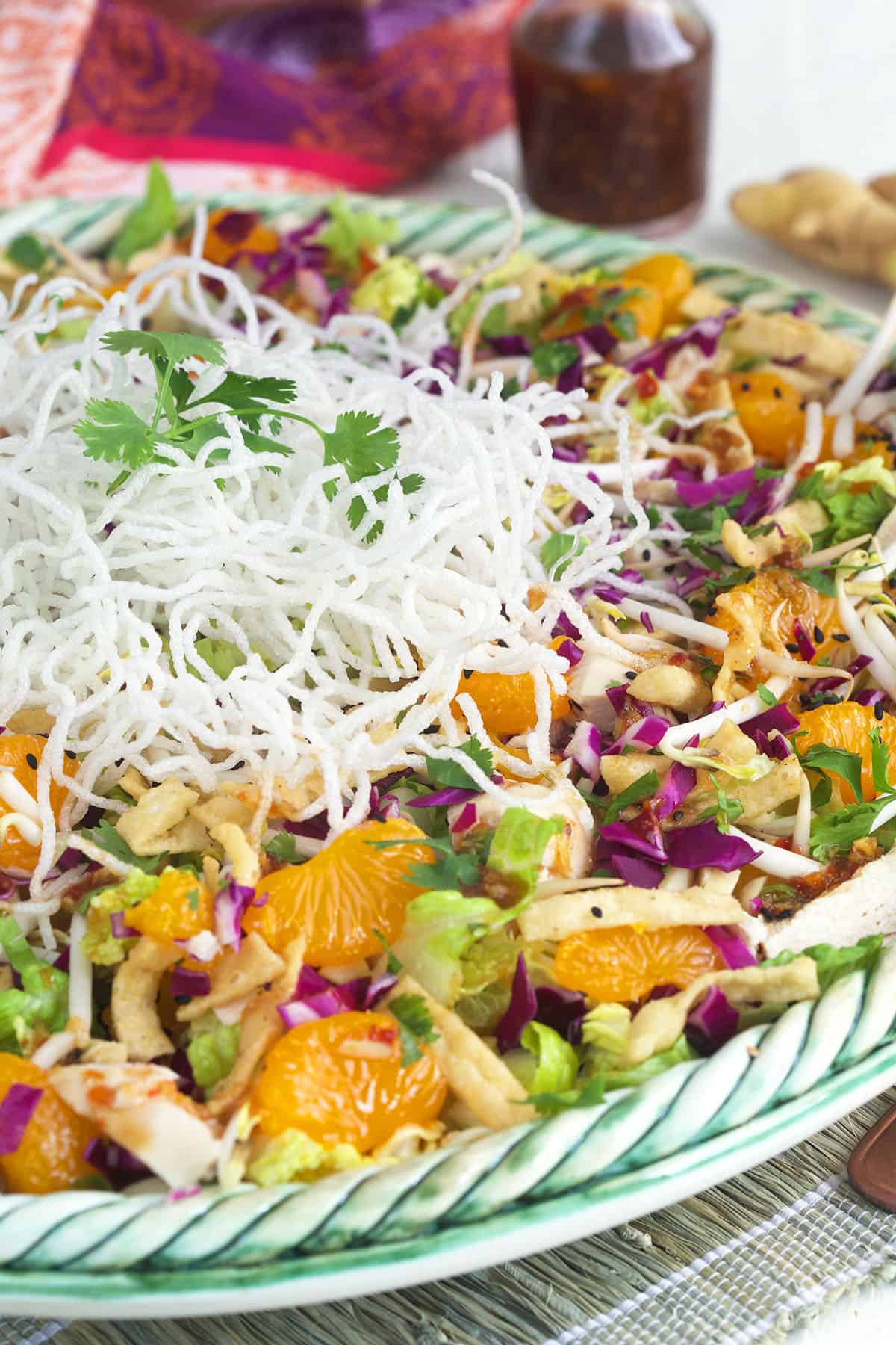 Crispy rice noodles are placed on top of a full salad. 