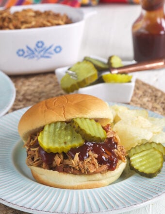 Pickles are placed on a bbq sandwich.