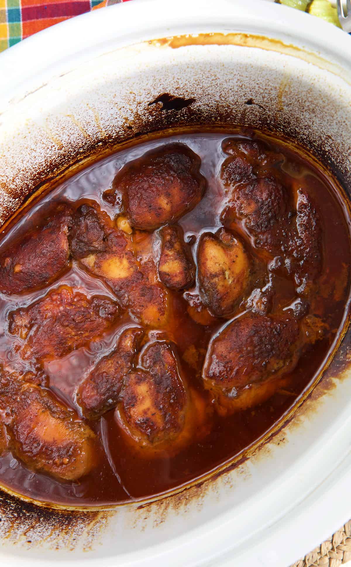 Chicken has been cooked in a Crockpot with chicken stock and bbq sauce.