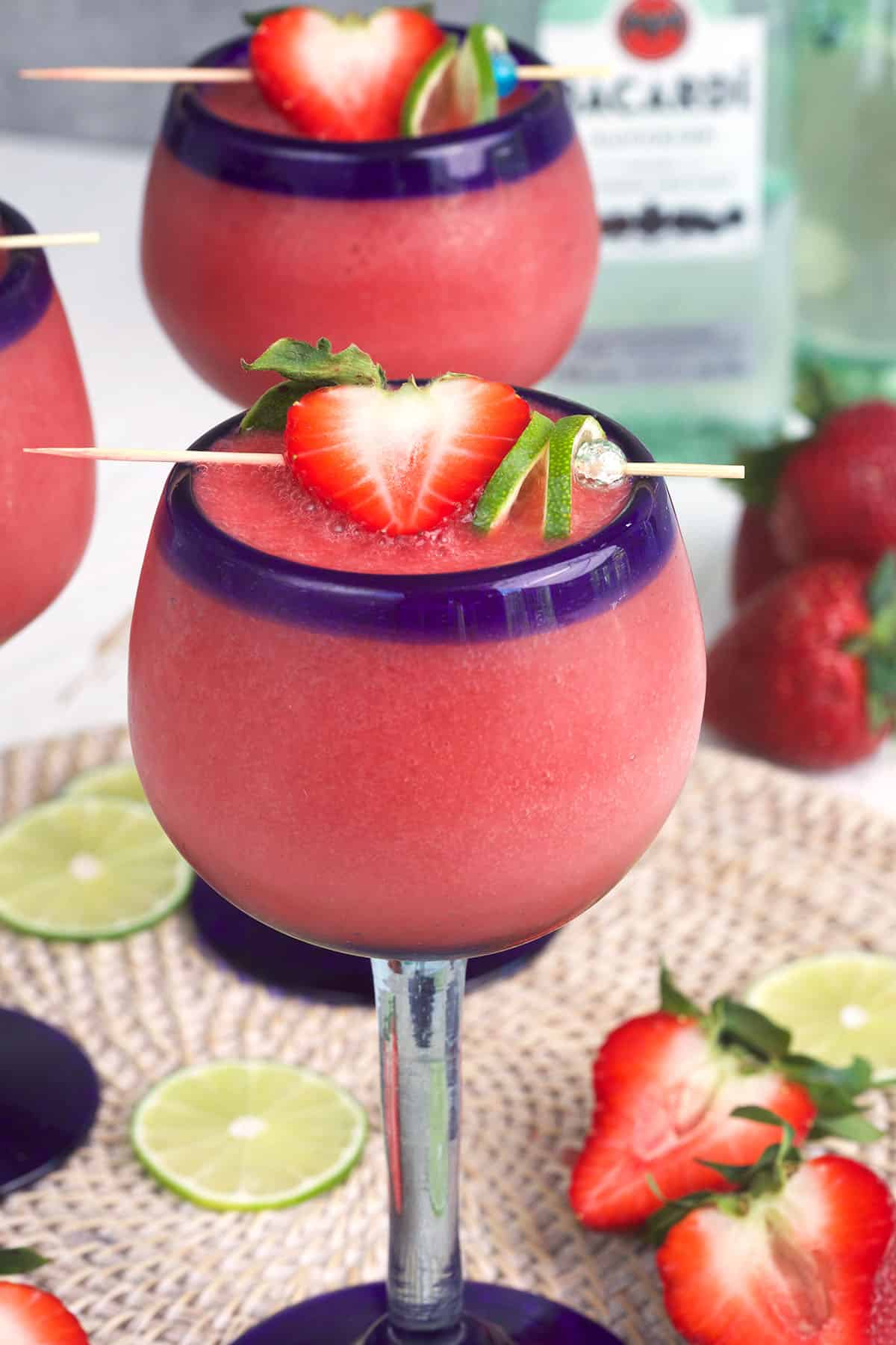 A blue rimmed glass is filled with frozen strawberry daiquiri. 