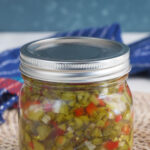 A jar of pickle relish is placed on a placemat.