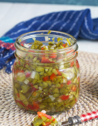 A spoon is placed next to a full jar of relish.