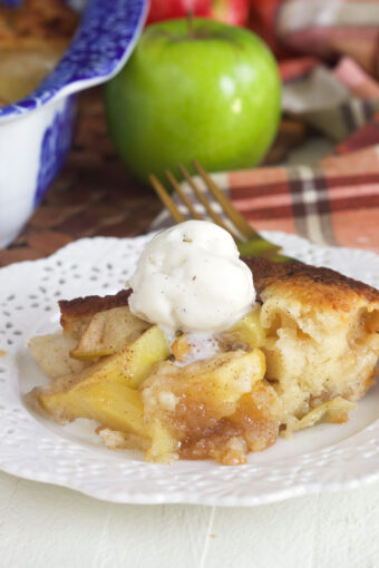 A serving of apple cobbler is topped with a scoop of ice cream.