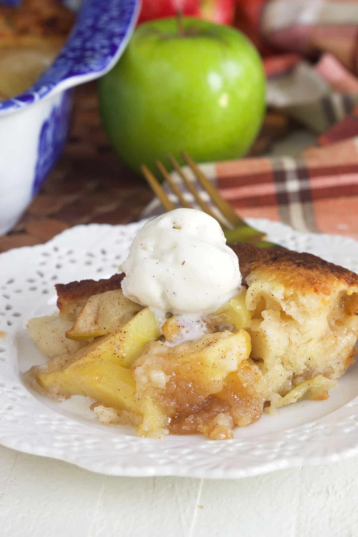 A serving of apple cobbler is topped with a scoop of ice cream. 