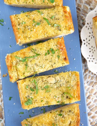Slices of garlic bread are placed on a blue plate.