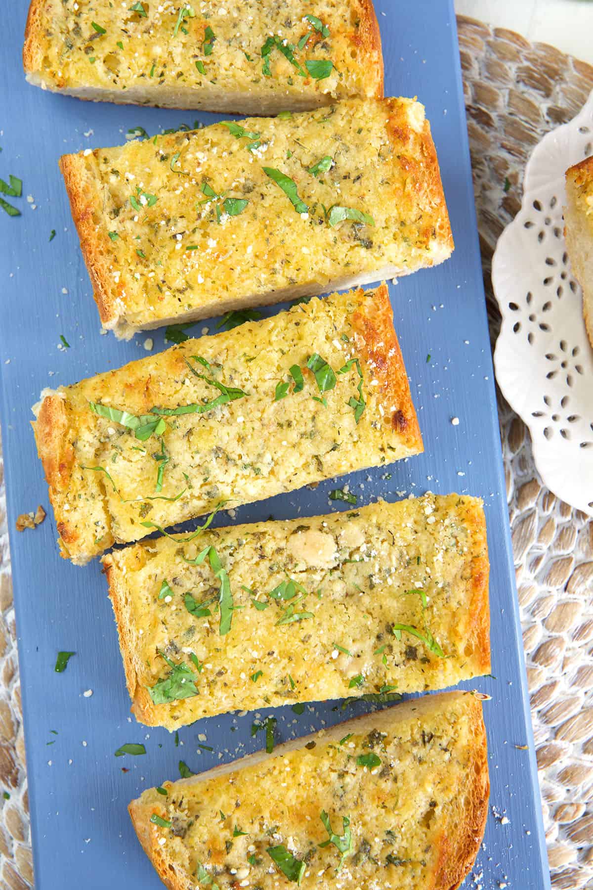 Slices of garlic bread are placed on a blue plate. 