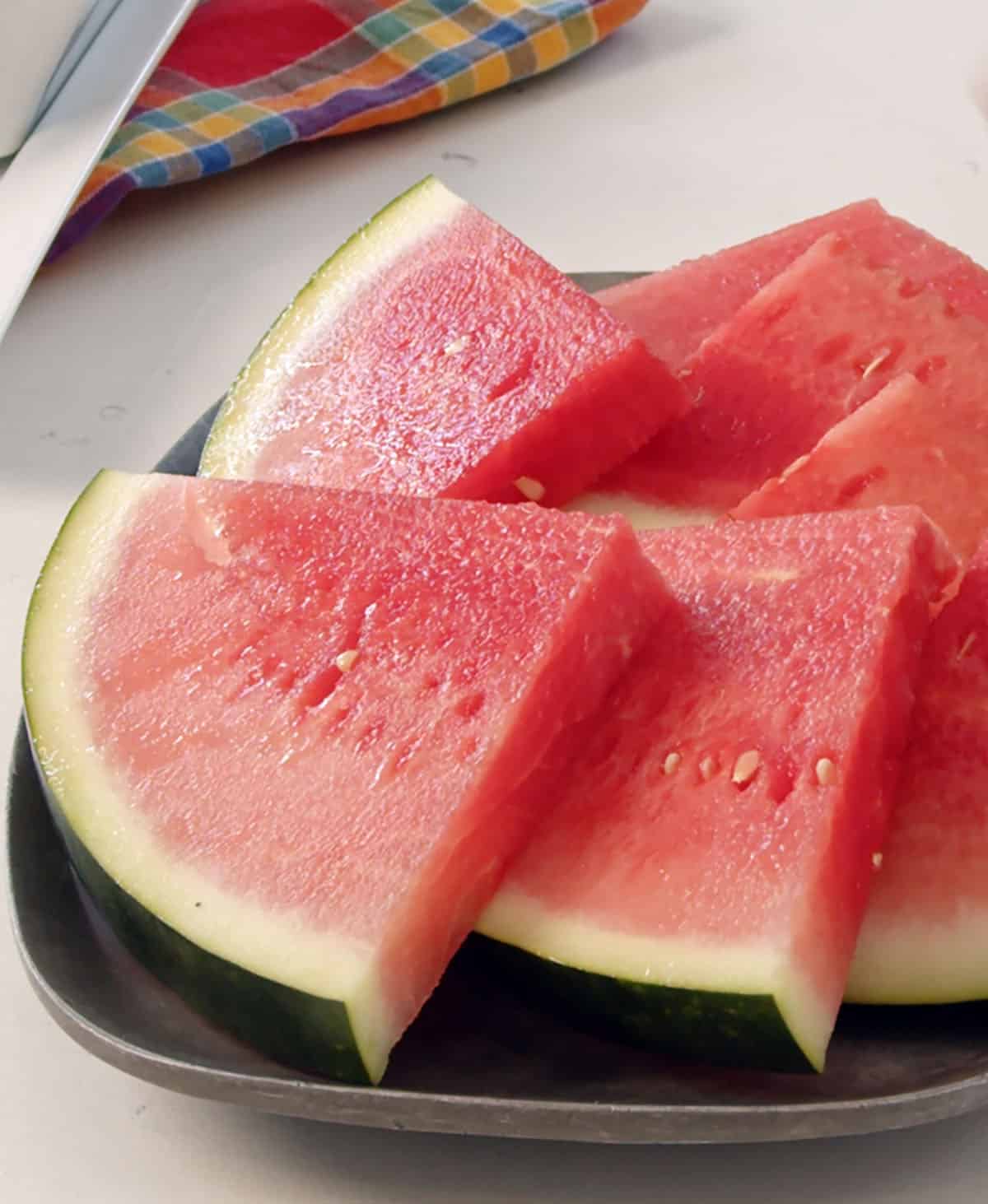Triangular slices of watermelon are placed on a plate. 