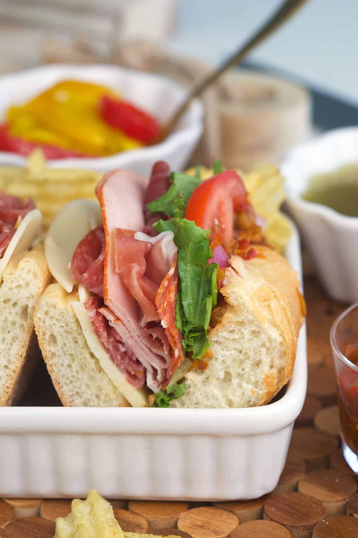Italian hoagie sliced and placed in a white square sandwich tray.