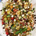 Balsamic reduction is drizzled all over panzanella salad.
