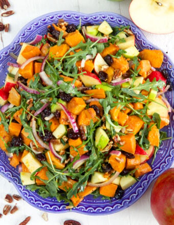 A large blue serving plate is topped with sweet potato salad.