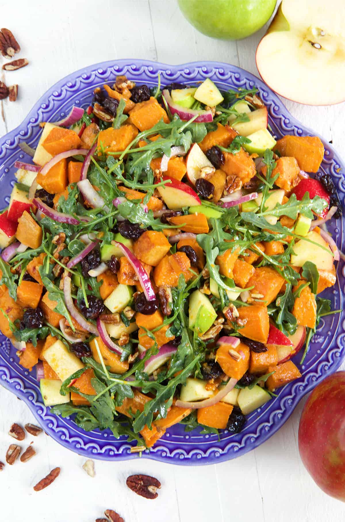 A large blue serving plate is topped with sweet potato salad. 