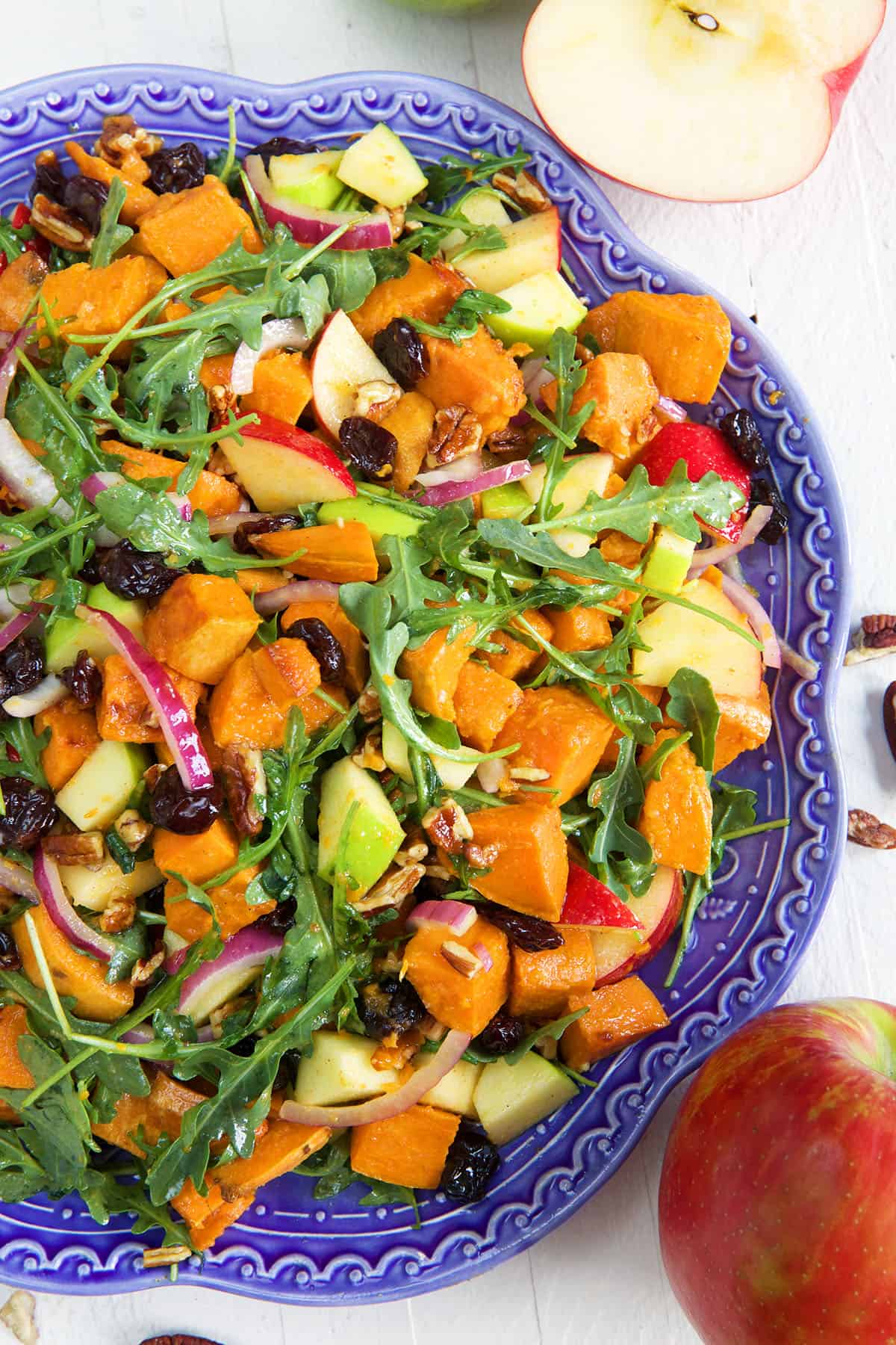 A blue salad bowl is filled with sweet potato salad. 