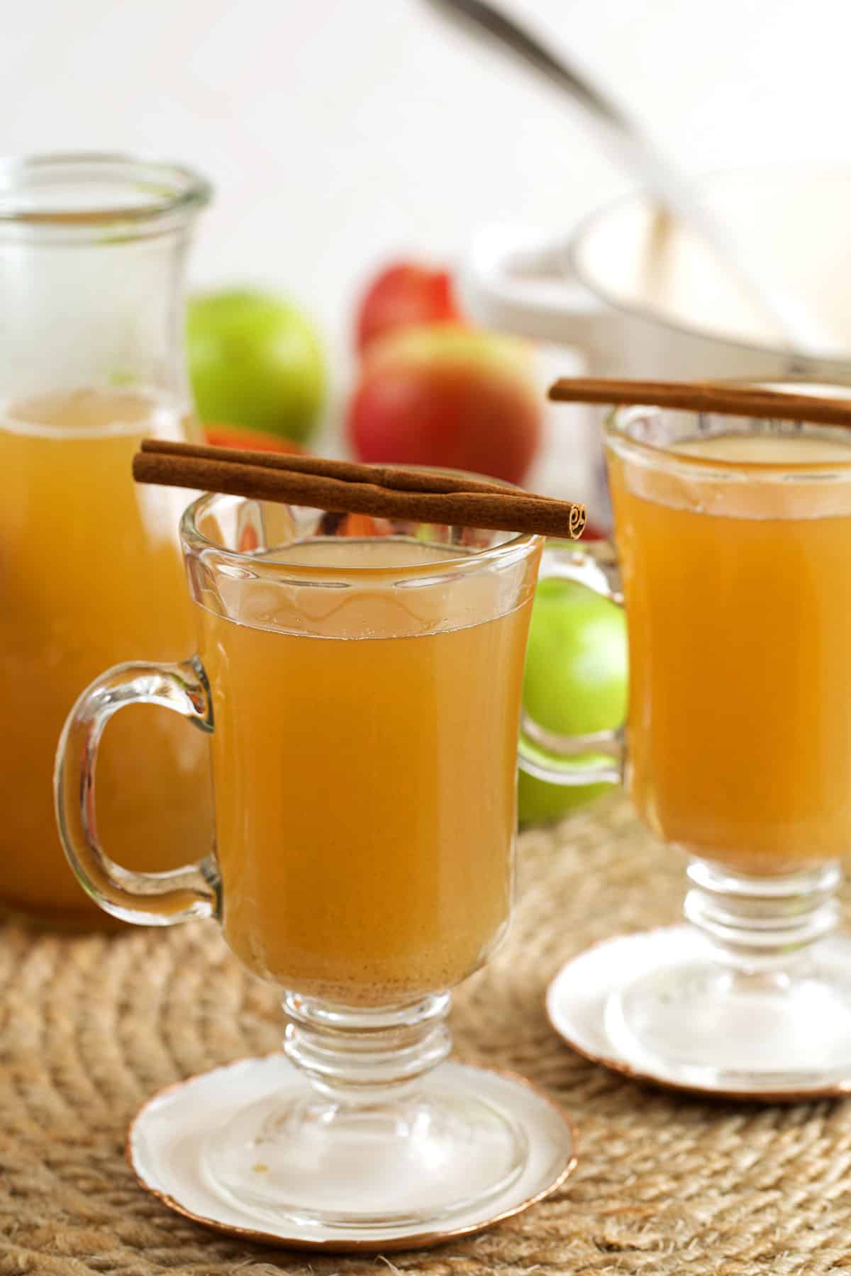 Homemade apple cider in glasses with cinnamon sticks