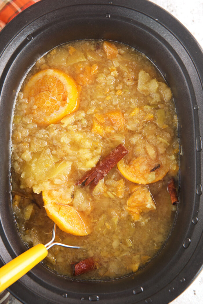 Mashing homemade apple cider in crockpot