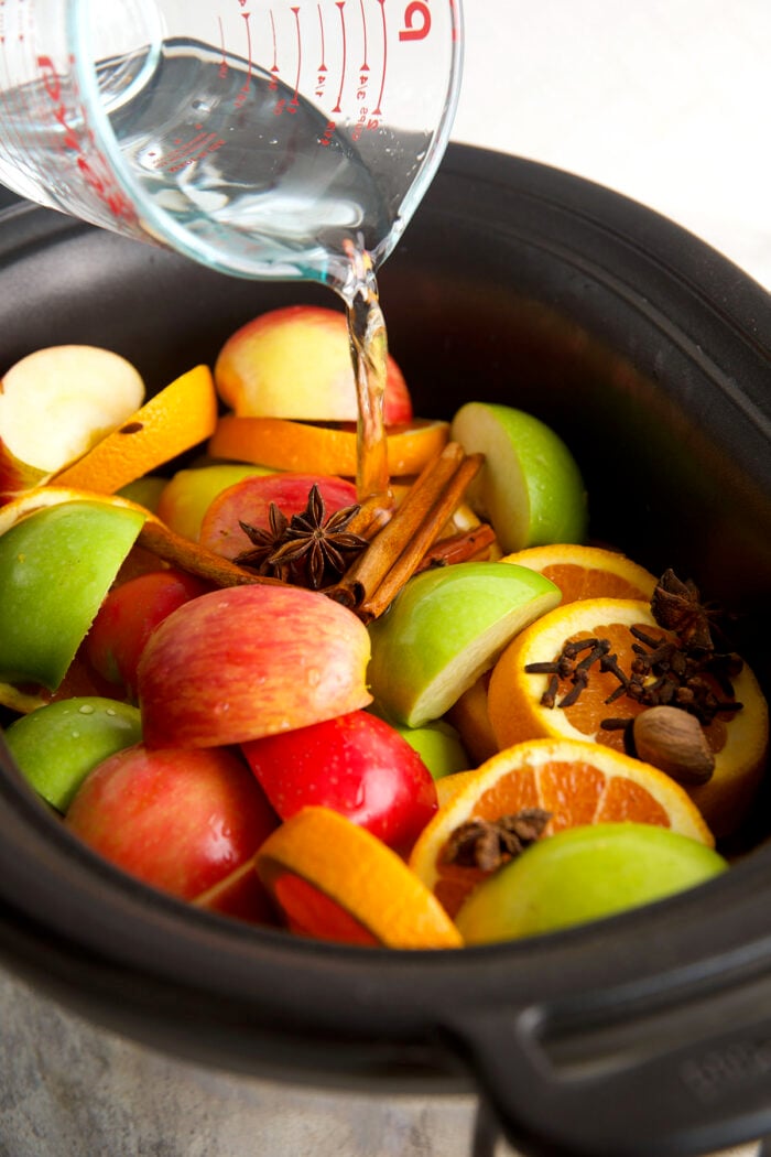 Pouring water into crockpot for apple cider