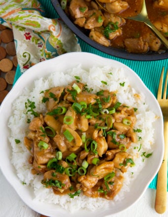 A serving of bourbon chicken is presented on a pile of white rice.