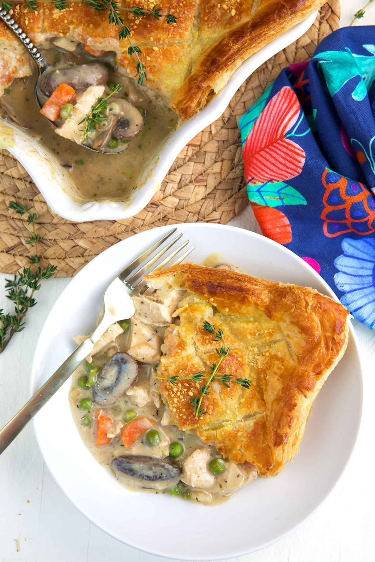 A fork is placed on a plate with a single serving of pot pie. 