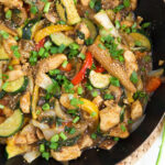 A skillet is filled with chicken stir fry.