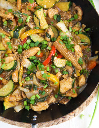 A skillet is filled with chicken stir fry.