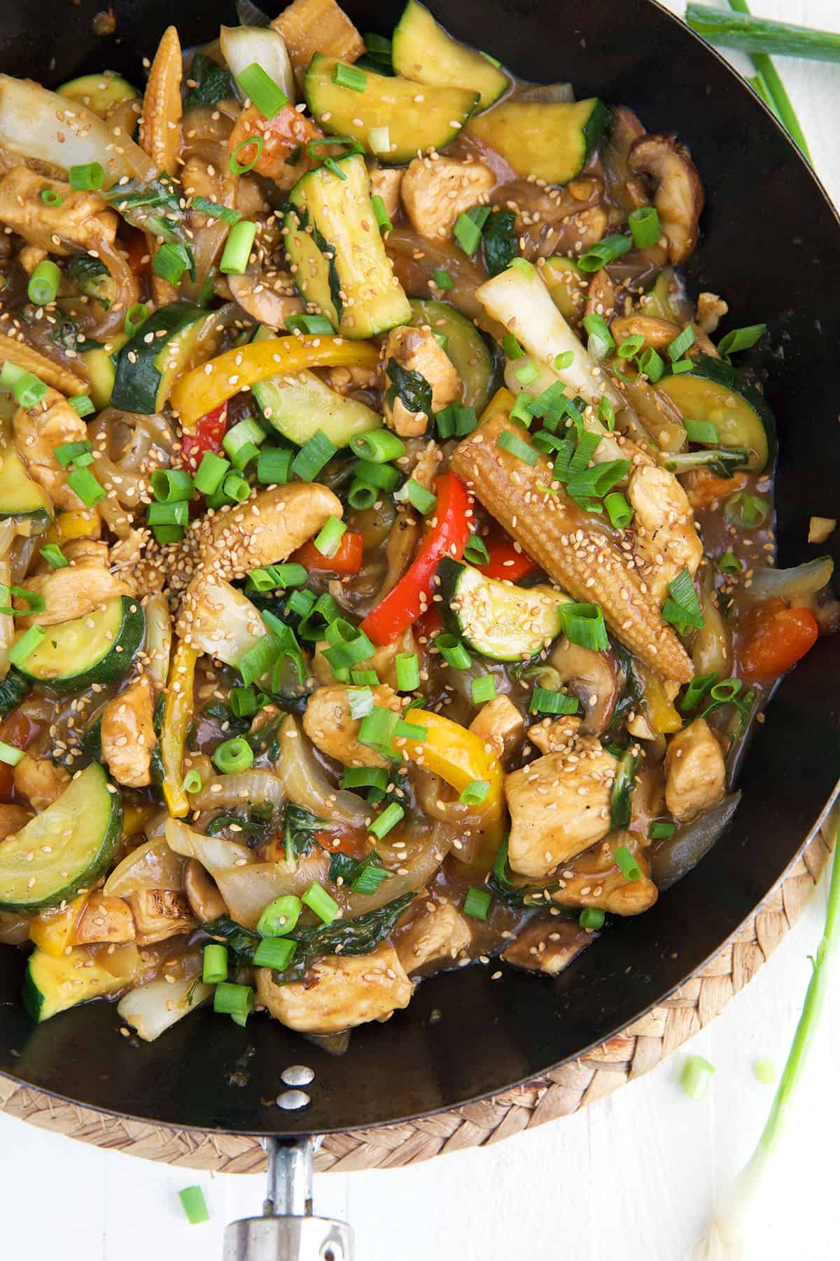 A skillet is filled with chicken stir fry. 