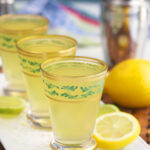 Lemons are placed next to a line of green tea shots.