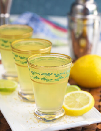 Lemons are placed next to a line of green tea shots.