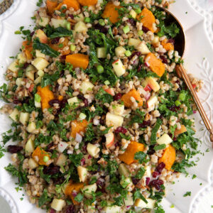 A white serving dish is topped with farro salad.