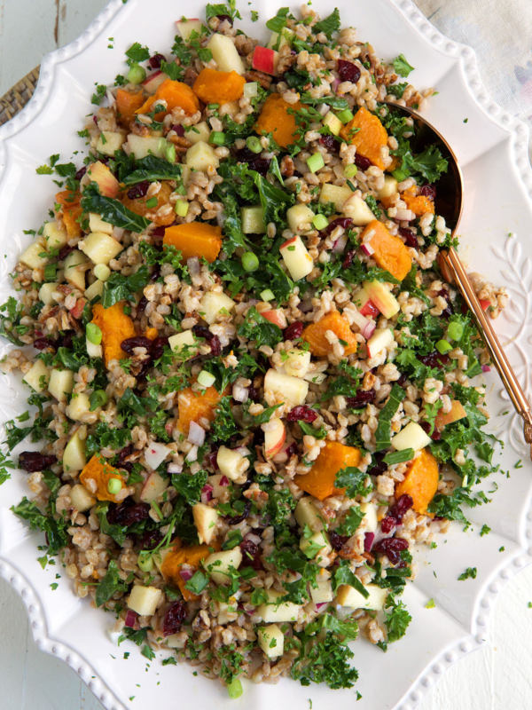A white serving dish is topped with farro salad.