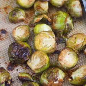 Cooked brussel sprouts are presented on a baking sheet.
