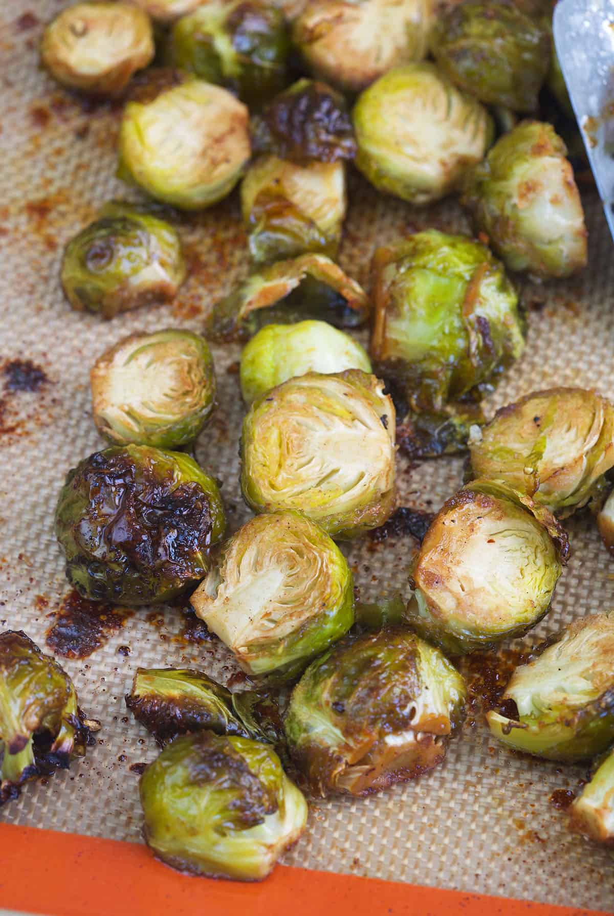 Cooked brussel sprouts are presented on a baking sheet.