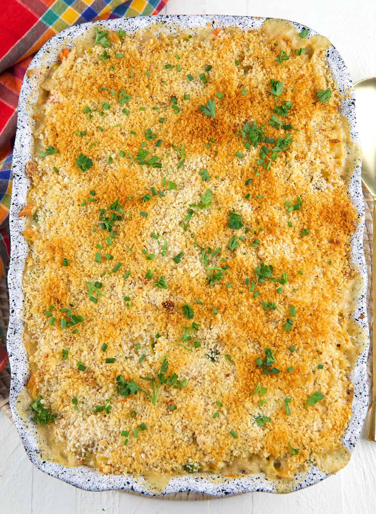A casserole dish is filled with baked chicken noodle casserole.