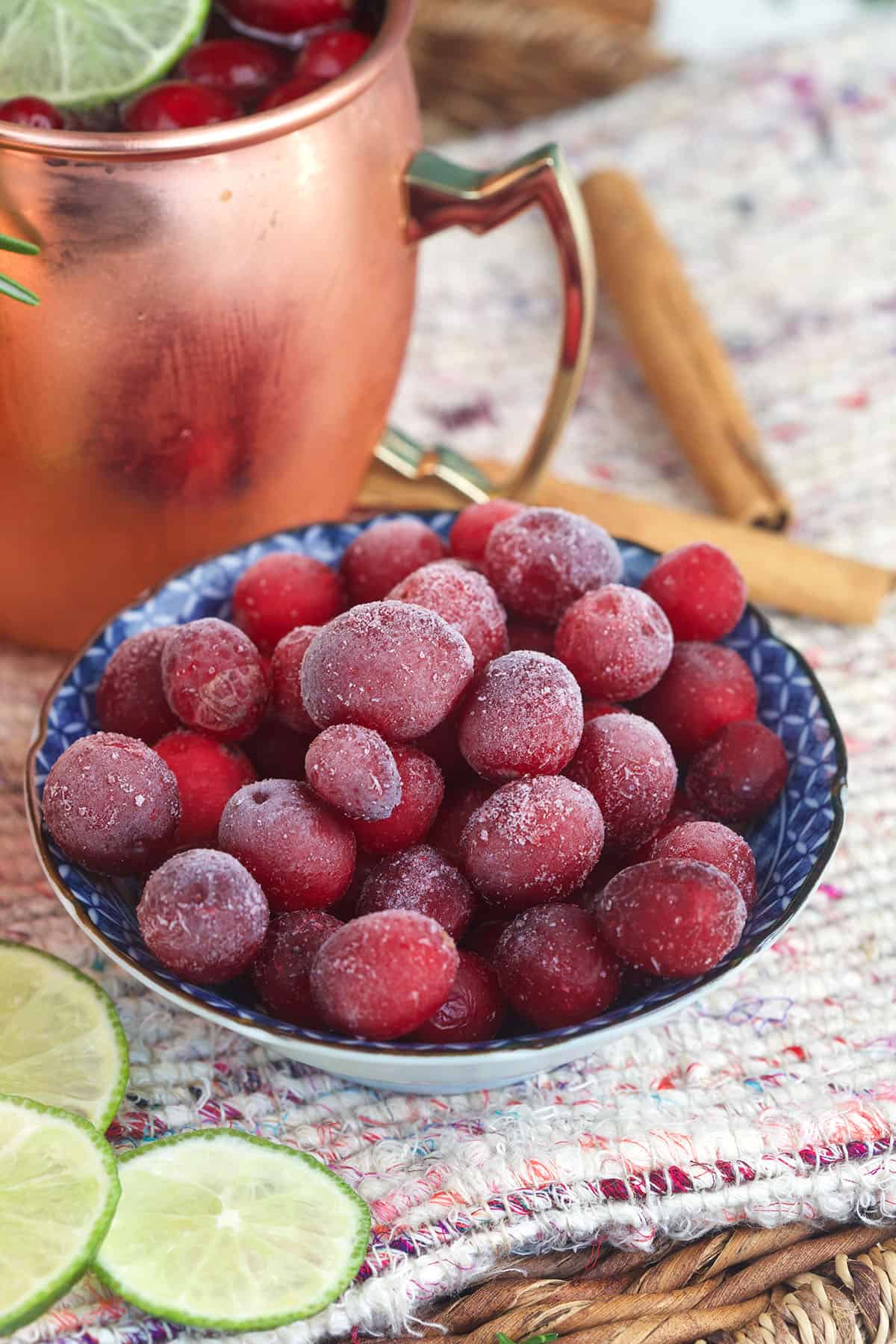 A small bowl filled with frozen cranberries is placed on a table. 
