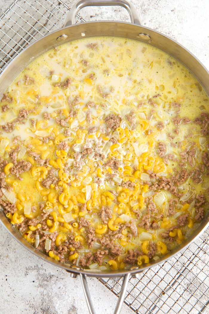 Ingredients for hamburger helper cheeseburger macaroni in skillet