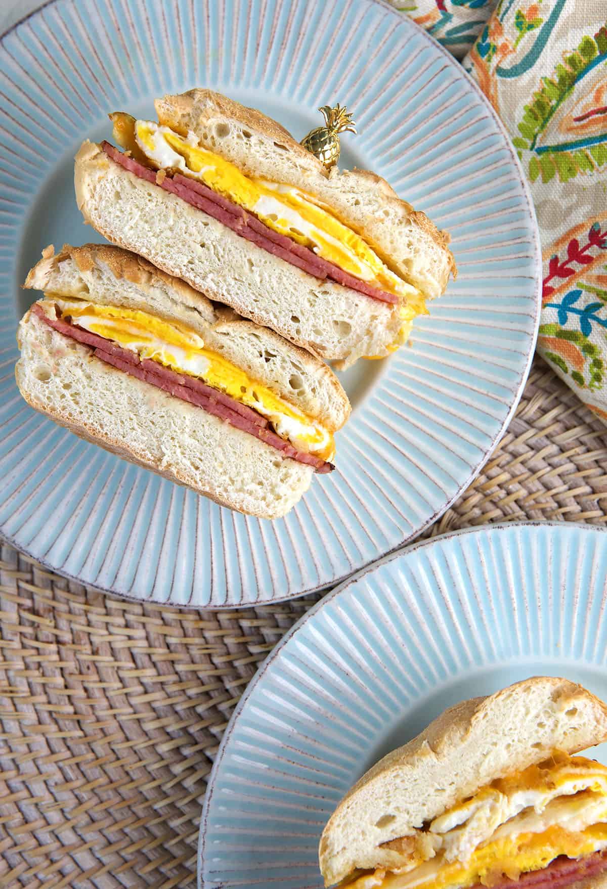 Two halved sandwiches are placed on round plates.