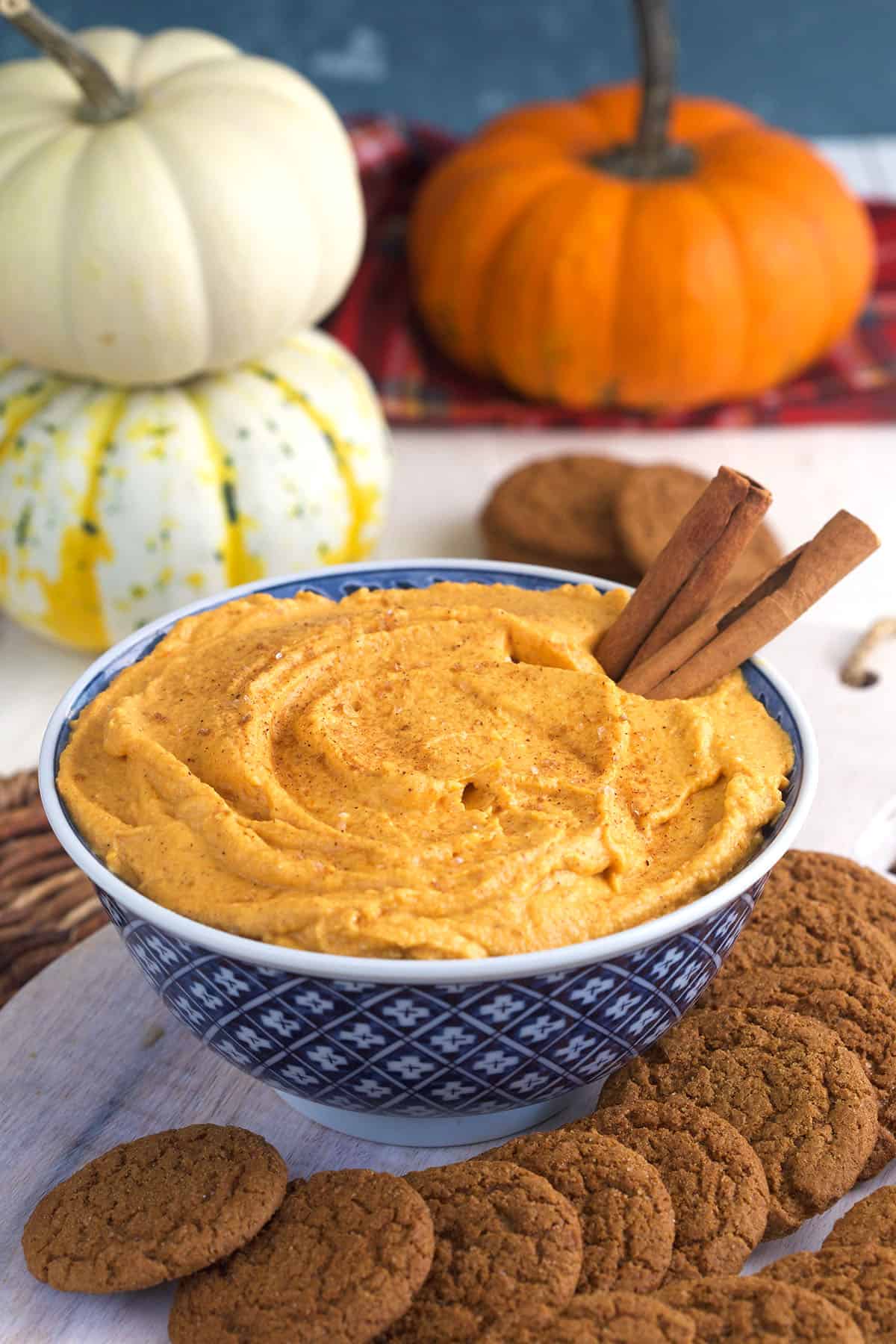 A blue and white bowl is filled with pumpkin dip. 